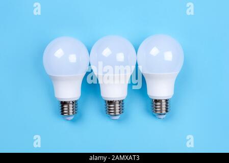 Three LED bulbs on blue background. Saving energy concept. Stock Photo