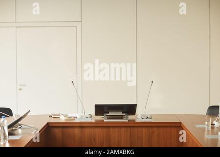 Image of big wooden table with monitor and microphones on it at modern board room Stock Photo