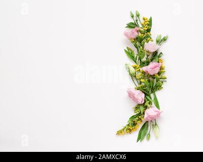 Floral border with pink and yellow flowers on a white background with a copy space. Use for invitations, greetings