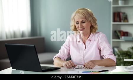 Senior female freelancer working on laptop at home, successful business lady Stock Photo