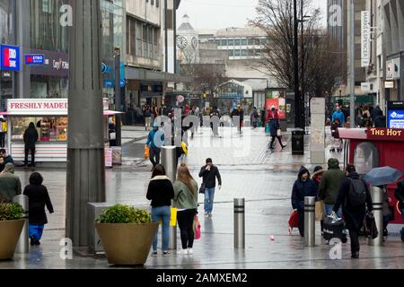 Shoppers in High Street in wet weather in winter, Birmingham city centre, UK Stock Photo