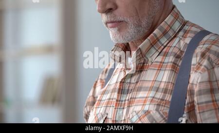 Closeup of old man wearing checkered shirt and suspenders, old-fashioned style Stock Photo