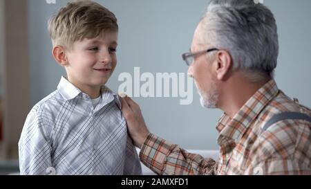 Grandpa giving advice to boy, teaching younger generation, sharing experience Stock Photo