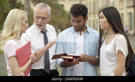 Experienced teacher talking with students about future scientific research Stock Photo