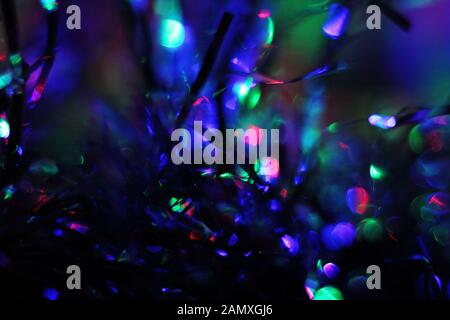 Closeup of the tinsel lit with colored light. Beautiful abstract multicolored background. Stock Photo