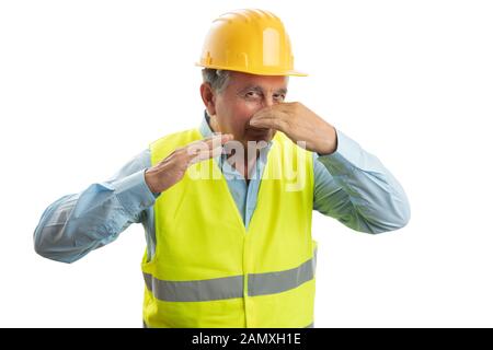 Old builder man holding nose with hand as bad smell gesture isolated on white background Stock Photo