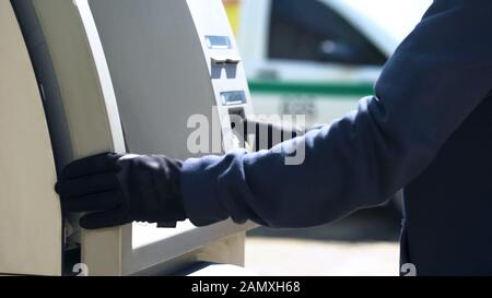 Security man checking safety of automated teller machine cash-in ...