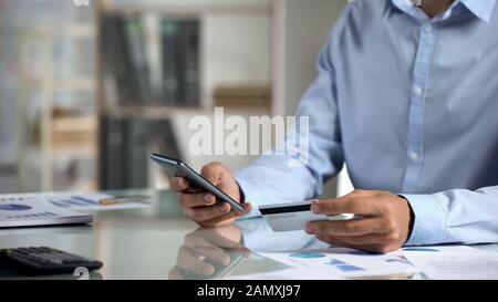 Office worker shopping online, typing credit card data on smartphone application Stock Photo