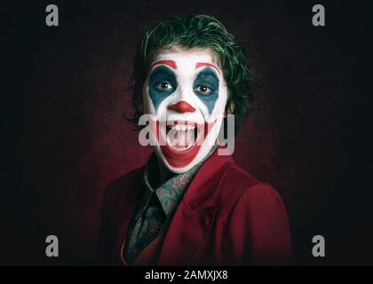 smiling boy dressed as Joker on dark background Stock Photo