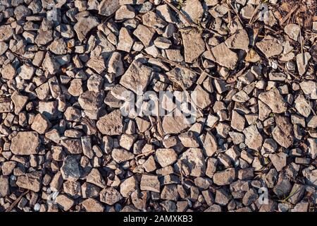 abstract background with dry uneven and different stones lit by sun light. Texture. Stock Photo