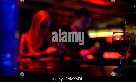 Couple using smartphone instead having fun in bar, internet addiction, defocused Stock Photo