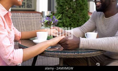 Happy newlyweds talking in cafe holding hands, drinking morning coffee together Stock Photo