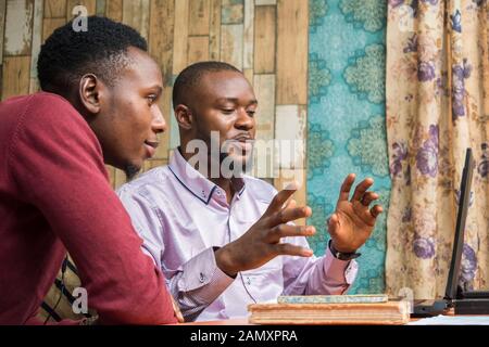 man explaining something to a colleague in the office with a laptop Stock Photo