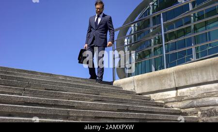 Male businessman having backache, going to work, radicular pain, slipped disc Stock Photo