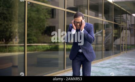 Middle-aged office worker suffering from strong migraine, headache disorder Stock Photo