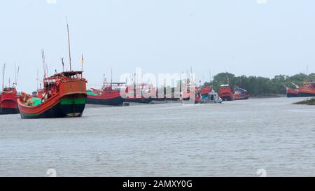 Many Commercial nautical sea vessels like trawler boat ship sailboat, all Red and Black Color code to strength coastal security anchored in protected Stock Photo