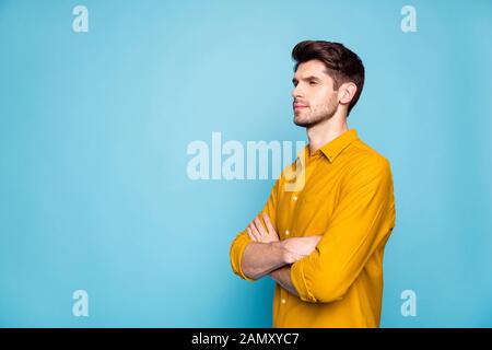 Photo of straight strict serious man standing with hands folded looking over empty space searching for new information isolated over pastel vivid Stock Photo