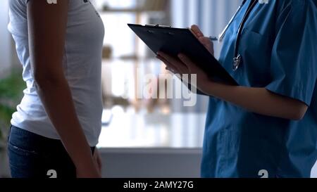 Female patient complaining of bloat, young doctor attentively listening Stock Photo