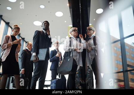 Group of business people with luggage standing in a row and registering at the reception before flight Stock Photo