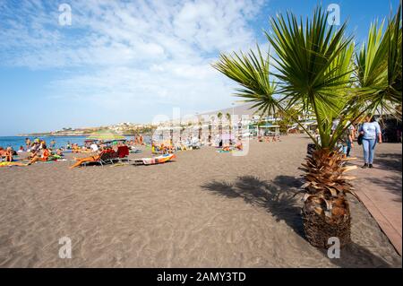 CANARY ISLAND TENERIFE, SPAIN - 26 DEC, 2019: Tourists are lying and relaxing on the beach called playa de torviscas. Stock Photo