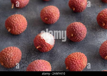 Fresh litchi fruits on a grey table close up Stock Photo