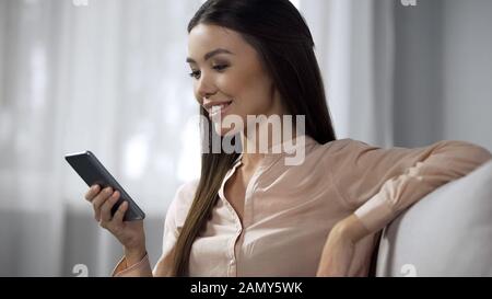Beautiful lady enjoying phone application, studying modern program interface Stock Photo