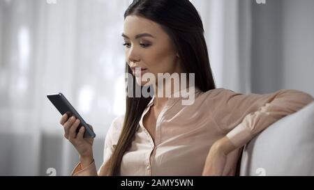 Pretty woman enjoying phone application, studying modern program interface Stock Photo