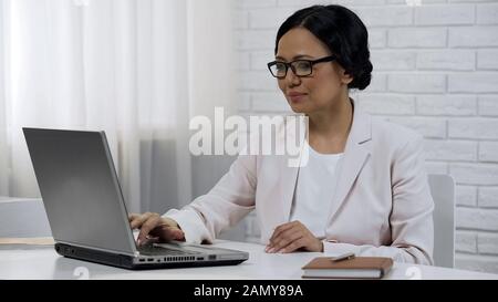 Asian business lady typing on laptop, beginning startup, successful project Stock Photo