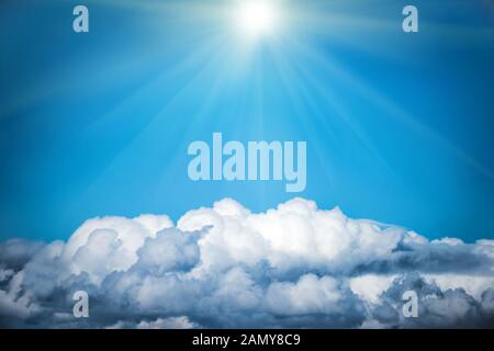 White clouds and bright sun on the blue sky. Nature background Stock Photo