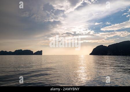 Dramatic Silhouette of mountains in the middle of andaman sea near Phi Phi Islands during sunset. Stock Photo