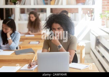 Pensive worker use laptop working in shared office Stock Photo