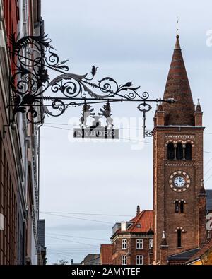 Decorative metal Nyborg Sign with two lions & St. Paul's Church, Sankt Pauls Kirke steeple in Copenhagen, Denmark Stock Photo