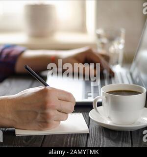 Home office workplace. Man analyzes and checking the graph on laptop Stock Photo