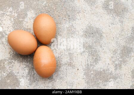 Top view three brown eggs on concrete. Stock Photo