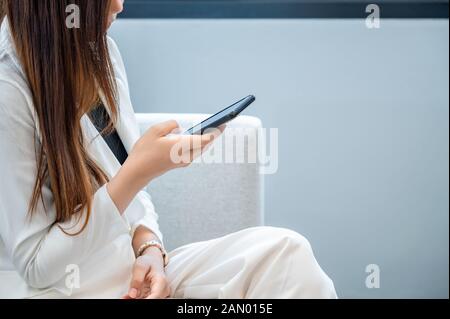 Business women wear white clothes glad to play mobile phone in a white background Stock Photo