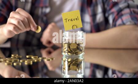 Travel word written above glass jar with money, savings for summer vacation Stock Photo