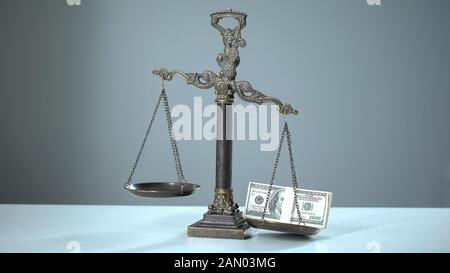 Dollars dominates on scales, social inequality concept, wealth and poverty Stock Photo