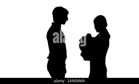 Silhouette of happy family, mother holding new-born baby father standing near by Stock Photo