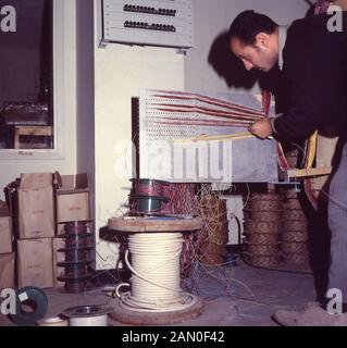 1960s, historical, a male electrician doing wiring or cabling installation work, Saudi Arabia. Stock Photo