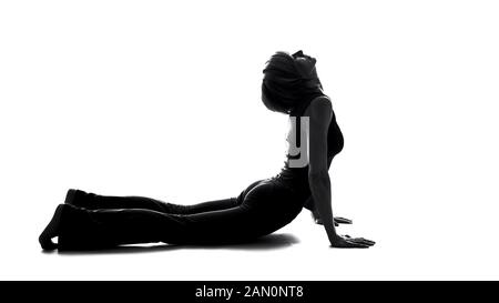 Young female making upward facing dog pose, yoga training, health care fitness Stock Photo