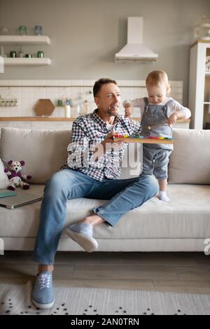 Mature man in a checkered shirt playing with his daughter Stock Photo