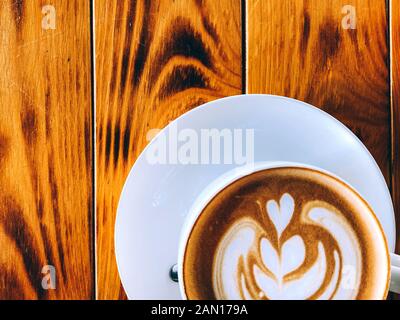 Cup of cappuccino standing on a wooden table, White cup on a plate with cookies, Texture of old wood panels, brown texture background, color, natural Stock Photo