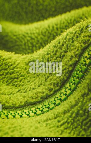 Close up shot of a YKK plastic zip fastener / zipper on fleece jacket. Metaphor keep mouth zipped, zipped lips, zipped file, green abstract. SEE NOTES Stock Photo
