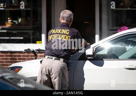 Parking Enforcement man places citation ticket on car Stock Photo