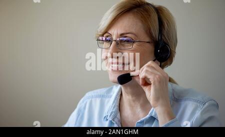 Smiling senior woman with headset dating online, love in old age, romantic Stock Photo