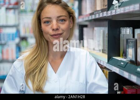 Portrait of smiling young woman standing in pharmacy Stock Photo