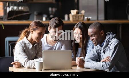 Diverse friends hang out in cafe using laptop Stock Photo