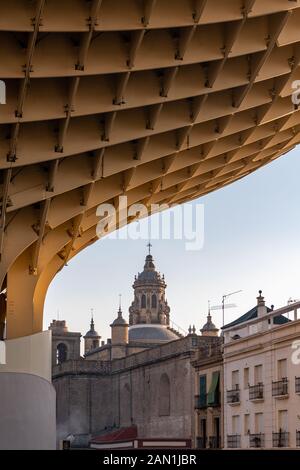 Jurgen Mayer's timber Metropol Parasol, in Plaza de la Encarnacion, Seville, frames the 16th century renaissance tower of Iglesia de la Anunciacion. Stock Photo