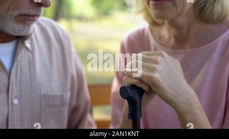 Female pensioner leaning on walking stick, husband support, old age disability Stock Photo