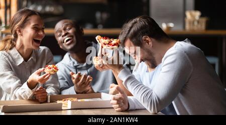 Happy multiracial friends enjoy tasty pizza from takeaway delivery Stock Photo